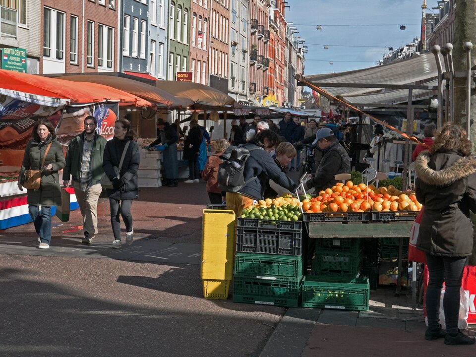A fruit stall on the Albert Cuyp market, shoppers passing under the awnings