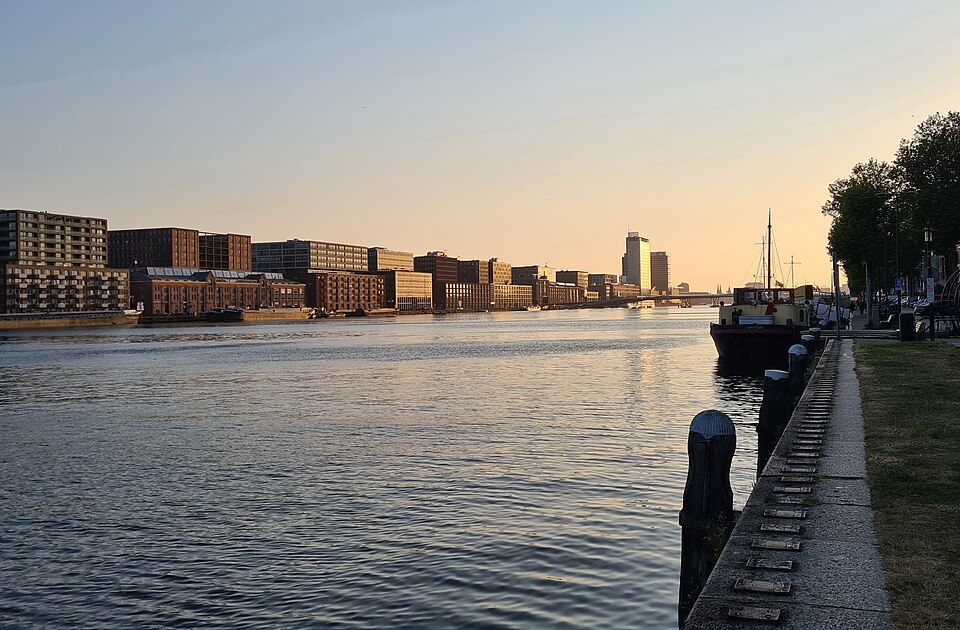 Converted warehouses along the IJhaven at sunset, a barge at the quay
