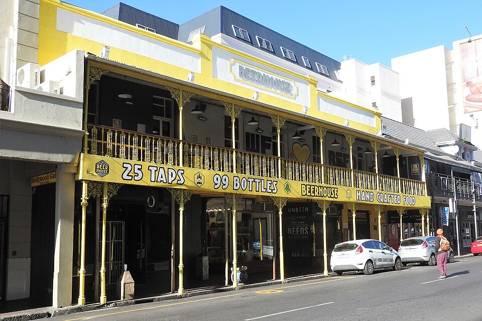 A yellow Victorian building with iron lacework and a balcony over Long Street