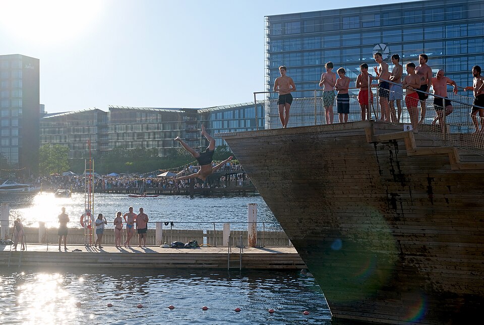 Swimmers diving from the wooden harbour bath, crowds along the quay