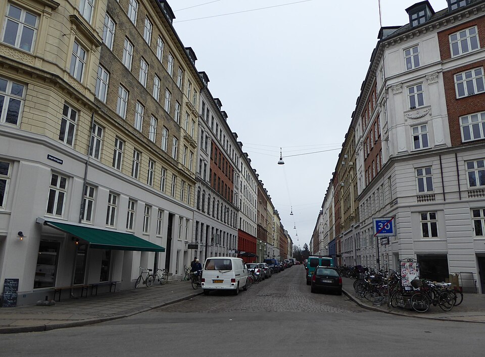 Cobbled Jægersborggade between tenement fronts, awnings and parked bicycles