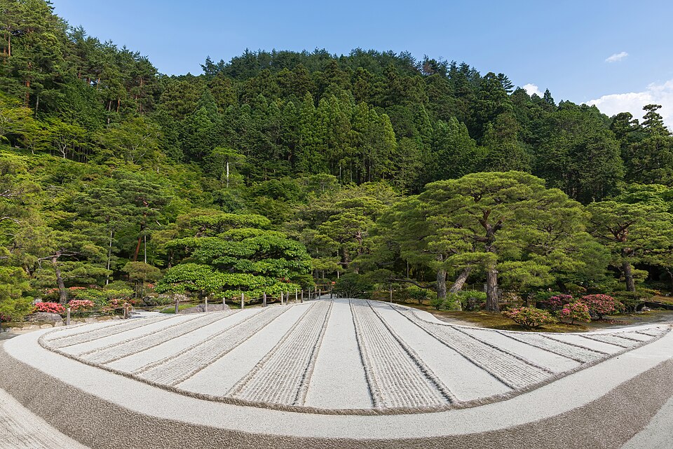 The raked sand garden at Ginkaku-ji below a wooded hillside