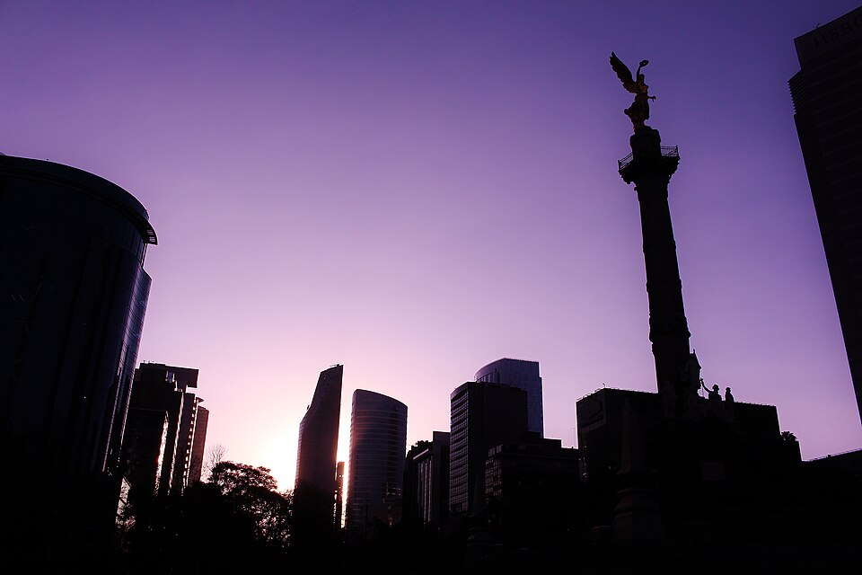 The Ángel de la Independencia in silhouette against a violet sunset