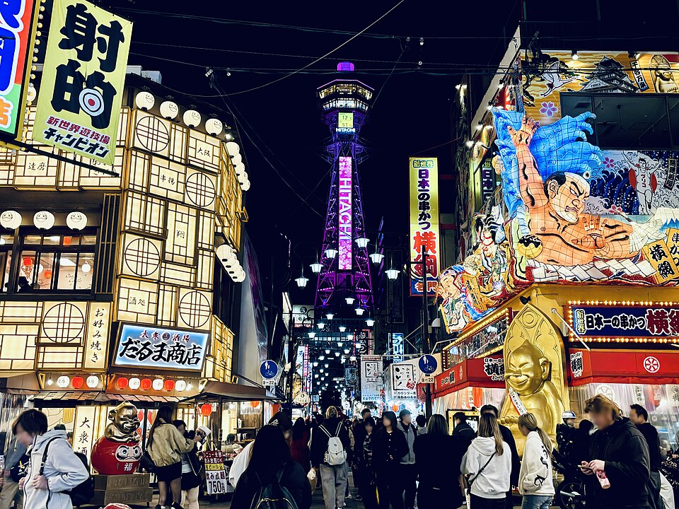 Tsūtenkaku lit above a crowded street of kushikatsu signs