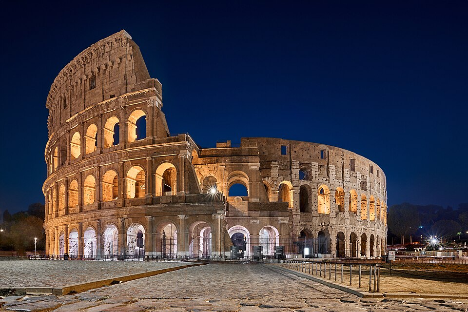 The Colosseum lit at blue hour, its arcades open to the dark