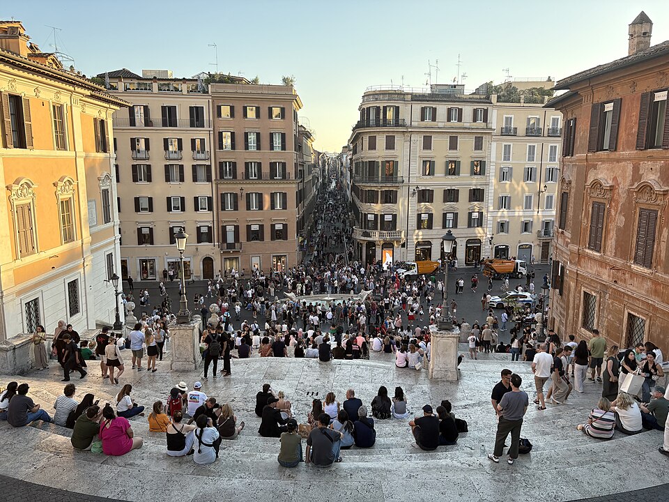 Crowds sitting on the Spanish Steps, Via Condotti running away below