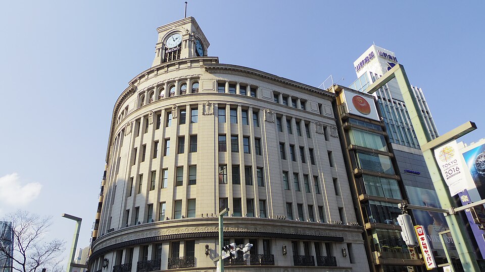 The Wako building’s curved stone front and clock tower at the crossing